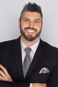 Headshot of Austin MacLennan, a smiling white man in a dark business suit.